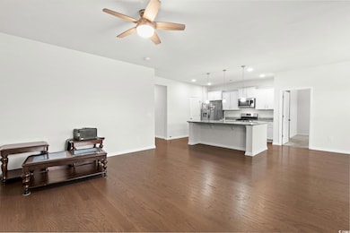Living area with recessed lighting, dark wood-style flooring, and ceiling fan