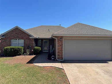 Ranch-style house with a shingled roof, brick siding, an attached garage, and concrete driveway