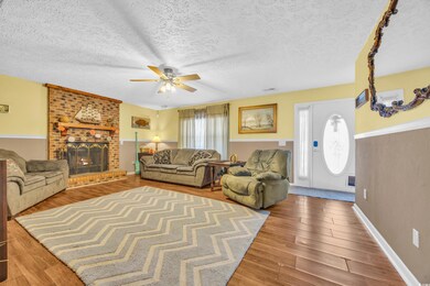 Living room featuring a brick fireplace, hardwood 