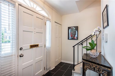 Entryway with dark tile patterned flooring and baseboards