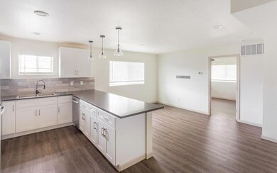 Kitchen featuring dark countertops, white cabinetr