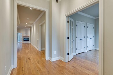 Foyer with hardwood floors.  Framed entry way into open living and dining room.  Large spare bedroom to the right of the foyer