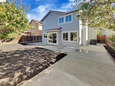 Back of house with a fenced backyard, a tile roof, a patio area, and stucco siding