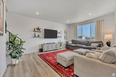 Living room with light wood-style floors and recessed lighting