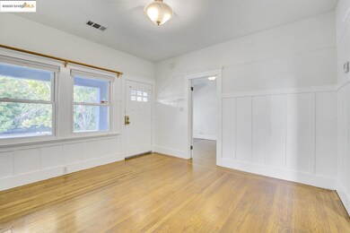 Foyer featuring a decorative wall, light wood-type flooring, and wainscoting
