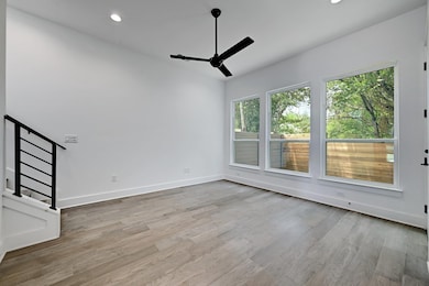 Empty room with baseboards, a ceiling fan, stairs