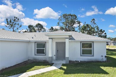 View of front of home with a front yard, roof with shingles, and stucco siding