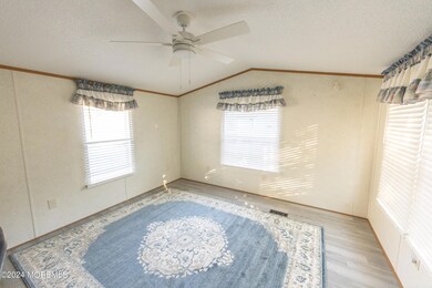 Living Room with Cathedral Ceiling, Plank Flooring & lots of natural light.