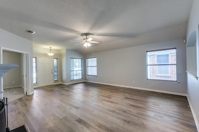 Unfurnished living room with ceiling fan, wood fi