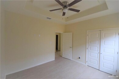 Unfurnished bedroom with a tray ceiling, a closet, visible vents, light wood-type flooring, and baseboards