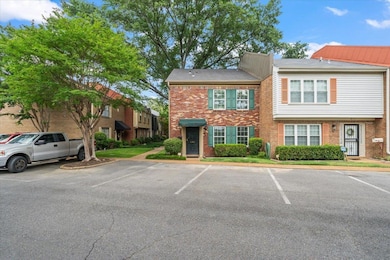 Townhome / multi-family property with brick siding and uncovered parking