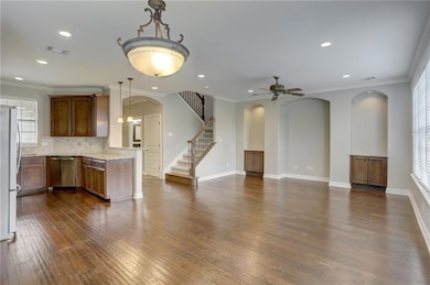 Unfurnished living room with arched walkways, bas
