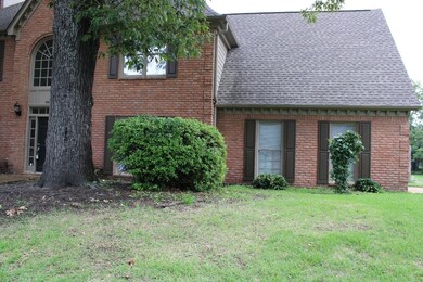 View of front of house featuring roof with shingles, brick siding, and a front lawn
