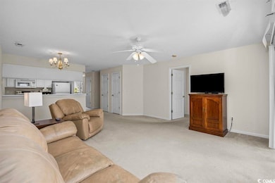 Living room with ceiling fan with notable chandeli