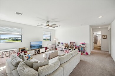 Living room with light colored carpet, visible ven