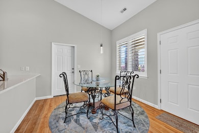 Dining space featuring light wood-style floors and vaulted ceiling