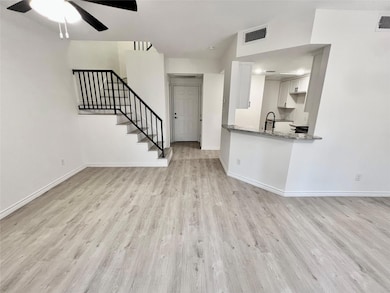 Unfurnished living room featuring a ceiling fan, b