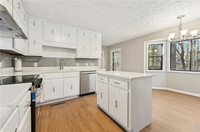 Kitchen featuring sink, white cabinetry, light woo