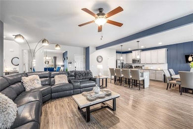 Living room with a chandelier, light wood-style floors, ceiling fan, and recessed lighting