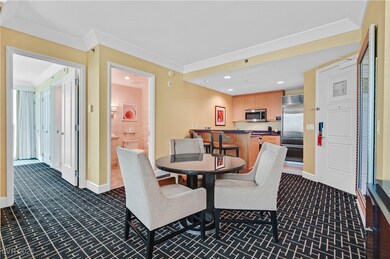 Dining room with dark colored carpet and recessed lighting