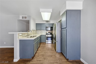 Kitchen with stainless steel appliances, a peninsu