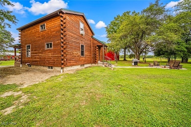 View of side of home with log exterior and a yard