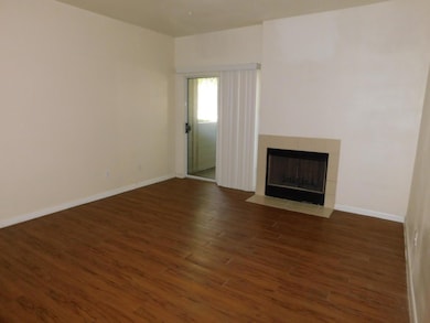 Unfurnished living room with dark wood-style flooring and a tile fireplace