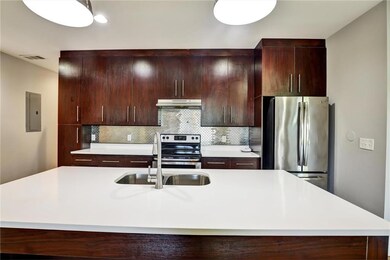 Kitchen featuring appliances with stainless steel finishes, light countertops, and tasteful backsplash