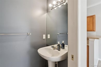 Bathroom featuring crown molding and a sink