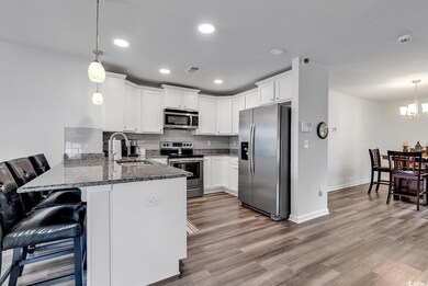 Kitchen featuring dark stone counters, stainless s