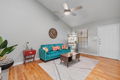 Living area featuring a ceiling fan, wood finishe