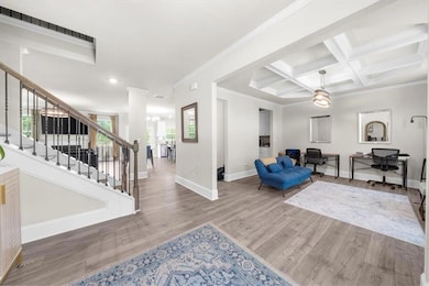 Living room featuring a chandelier, wood finished floors, stairs, recessed lighting, and coffered ceiling