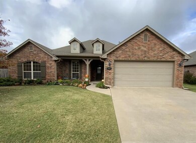 View of front of property featuring brick siding, a garage, concrete driveway, a front lawn, and roof with shingles