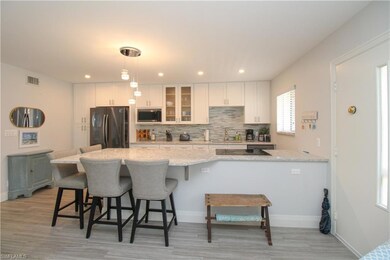Kitchen with black appliances, light stone counter