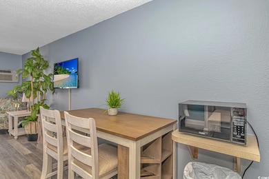 Dining room featuring an AC wall unit, a textured 