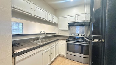 Kitchen featuring freestanding refrigerator, stain