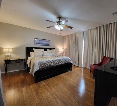 The master bedroom is downstairs and includes beautiful custom curtains from LOFT, and hardwood floors.