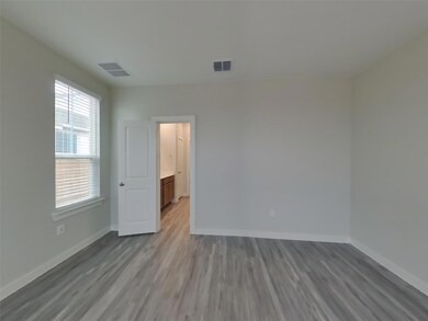 Unfurnished bedroom featuring visible vents, base