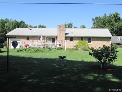 Back yard currently has garden, deck off the famil