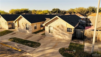 View of front facade with roof with shingles, brick siding, and stone siding