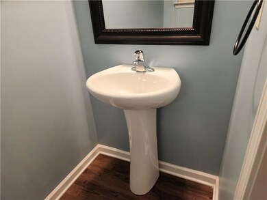 Bathroom featuring wood finished floors, baseboards, and a sink