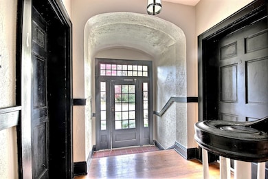 Entrance foyer with a textured wall and hardwood / wood-style flooring