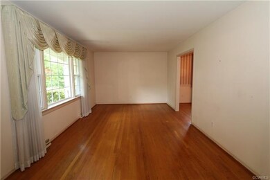 Living room features a triple window overlooking t