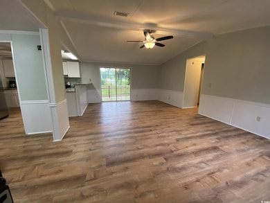 Unfurnished living room featuring ceiling fan, wai