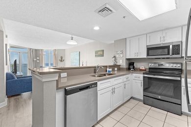 Kitchen featuring white cabinets, sink, appliances