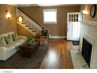 Living Room - Huge Living Room with immense fireplace. Wall Sconces, hard wood floors and original entry door all add up to a modern twist on Craftsmen detail.