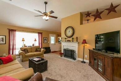 Large living room with plenty of natural light and notice the brand new carpet. Also, a fireplace with gas logs that is also see-through to the kitchen.