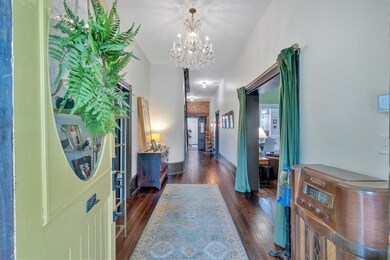 Corridor with a chandelier and dark wood-style flo