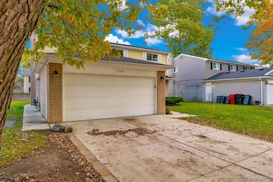 View of front of house featuring brick siding, driveway, and a front lawn