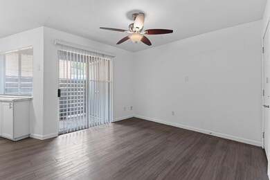 Unfurnished room featuring ceiling fan, dark wood